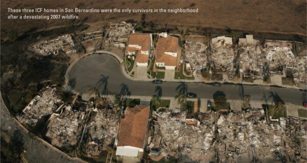 Aerial view of a wildfire-affected neighborhood with three intact ICF homes amidst ruins in San Bernardino. The surrounding houses are completely destroyed, reduced to ash and debris, highlighting the stark contrast between the surviving homes and the devastation.